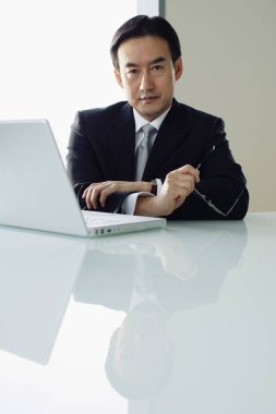 İş adamı masada oturuyor.,