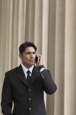 Takım elbiseli adam cep telefonu kullanıyor.