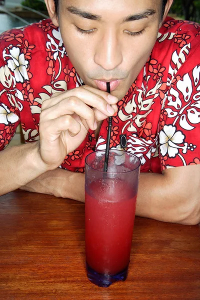 Homme en chemise florale sirotant boisson — Photo