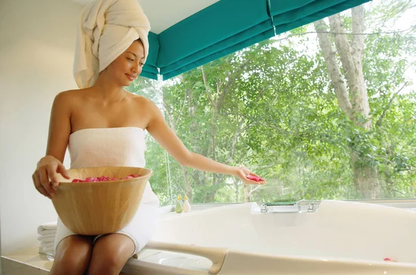 Nainen pyyhkeessä kylpyammeen reunalla. — kuvapankkivalokuva