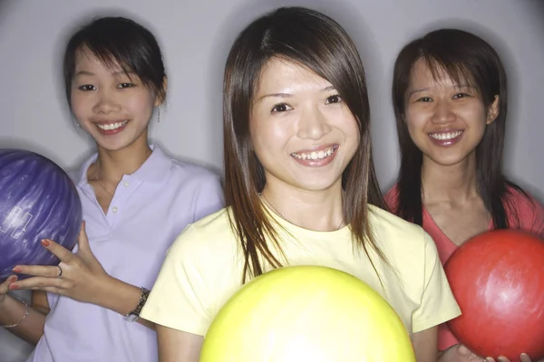 Három fiatal nők gazdaság bowling golyó — Stock Fotó