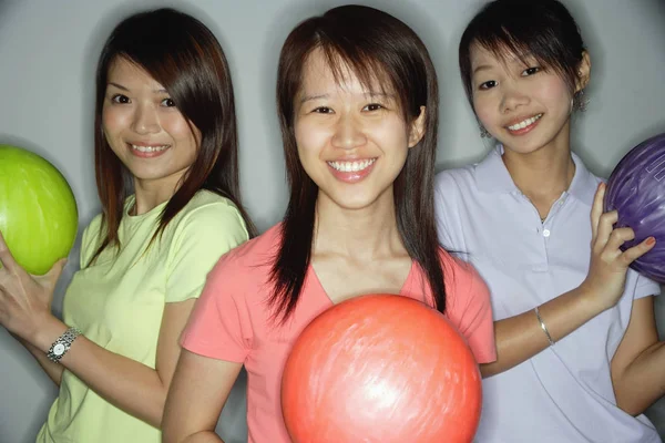 Tři mladé ženy držící bowlingové koule — Stock fotografie