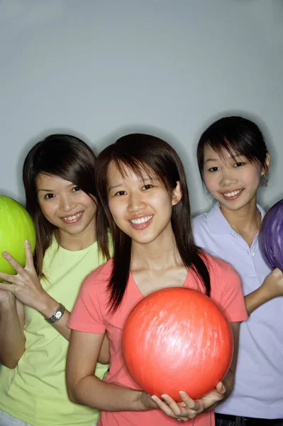 Tři mladé ženy držící bowlingové koule — Stock fotografie