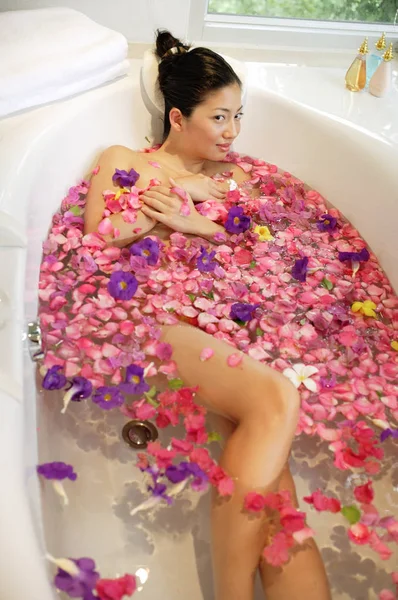 Kobieta w wannie, kwiaty pływające — Zdjęcie stockowe