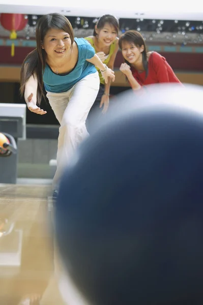 Kvinna som bowling och vänner tittar på — Stockfoto