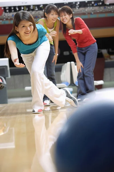 Kvinna som bowling och vänner tittar på — Stockfoto