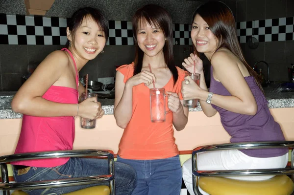 Women at bar holding drinks