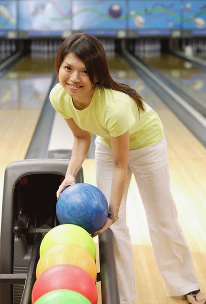 Žena výběr bowlingové koule — Stock fotografie