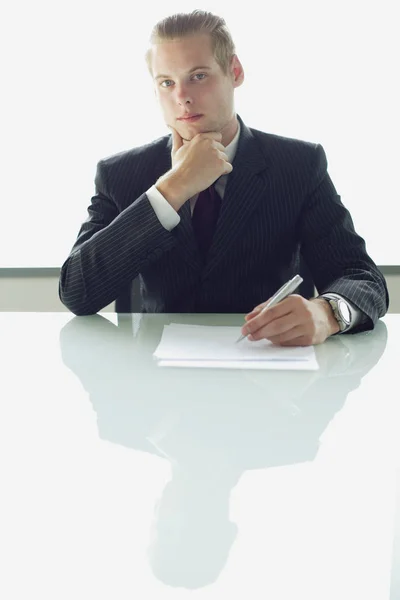Бизнесмен, сидящий за столом — стоковое фото