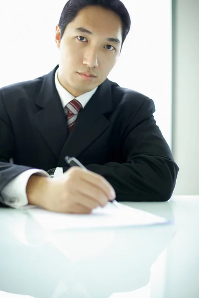 Бизнесмен с ручкой и бумагой — стоковое фото