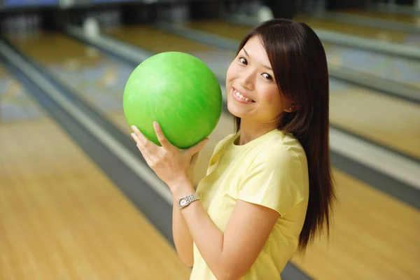 Женщина держит зеленый шар для боулинга — стоковое фото