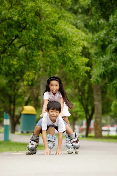 Asiático crianças patinagem — Fotografia de Stock