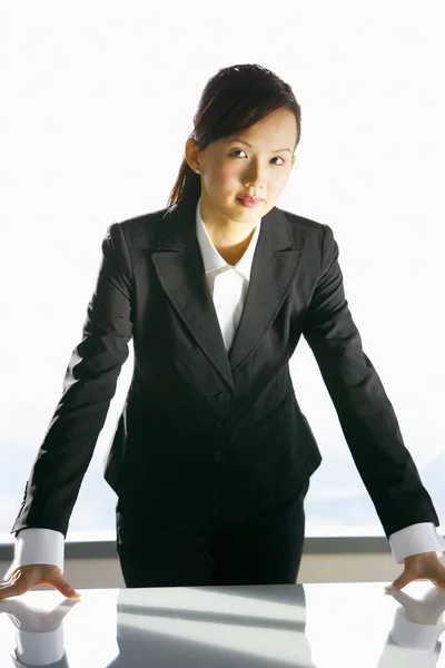 Geschäftsfrau stützt sich auf Tisch — Stockfoto