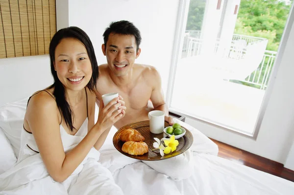 Pariskunta aamiaisella sängyssä — kuvapankkivalokuva