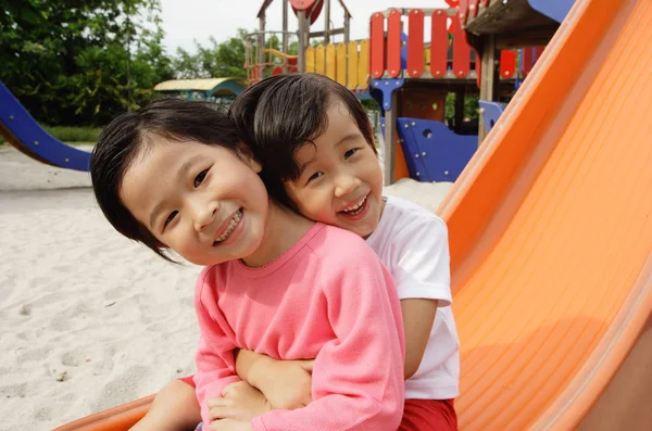 Duas meninas sentadas no slide — Fotografia de Stock