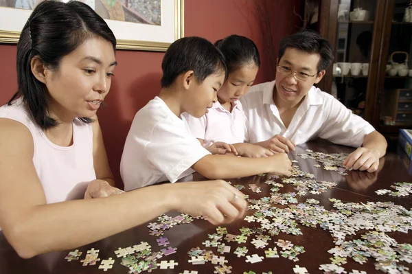 Family working on jigsaw puzzle