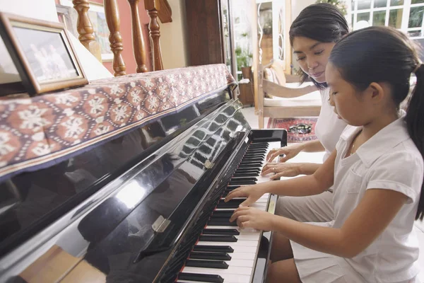 Mãe e filha tocando piano — Fotografia de Stock