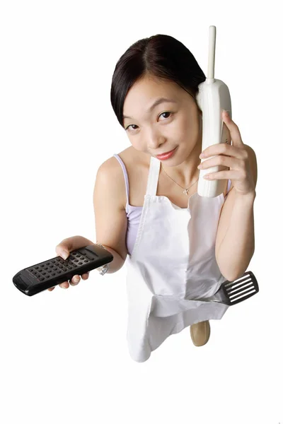 Mujer en delantal usando teléfono inalámbrico — Foto de Stock