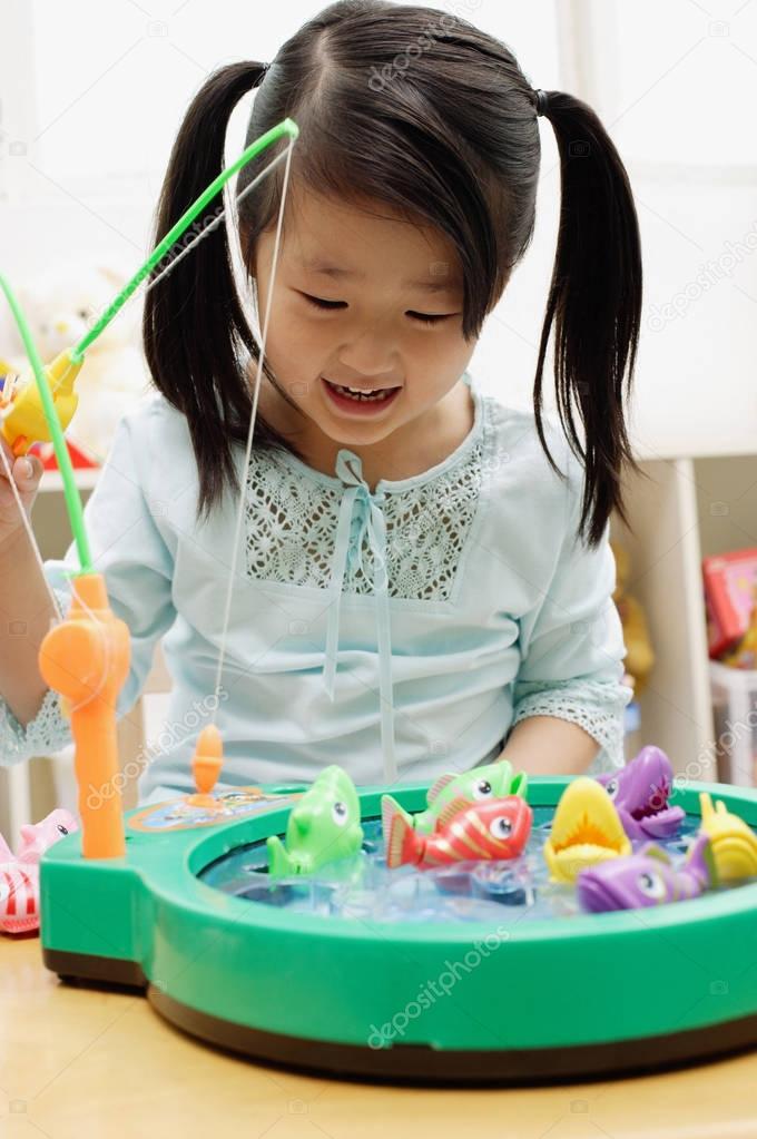 Girl playing with fishing game
