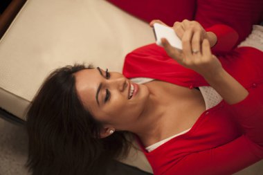 Kanepenin üzerinde telefon kullanan kadın