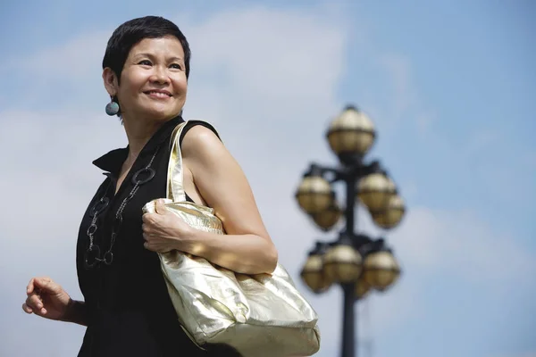 Mujer madura llevando bolso de hombro — Foto de Stock