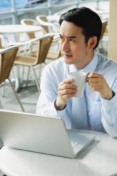 Homme d'affaires dans un café avec ordinateur portable — Photo