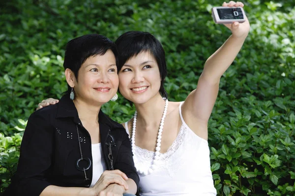 Mujeres lado a lado, sonriendo, tomando una foto — Foto de Stock