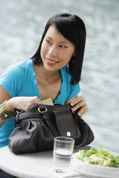 Jeune femme assise au café au bord de la rivière — Photo