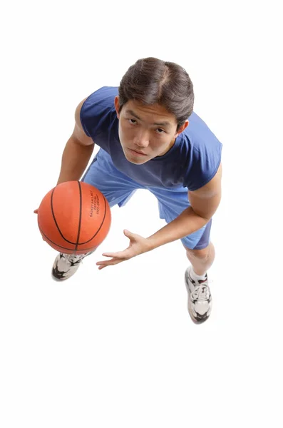 Mladý muž drží basketbal — Stock fotografie