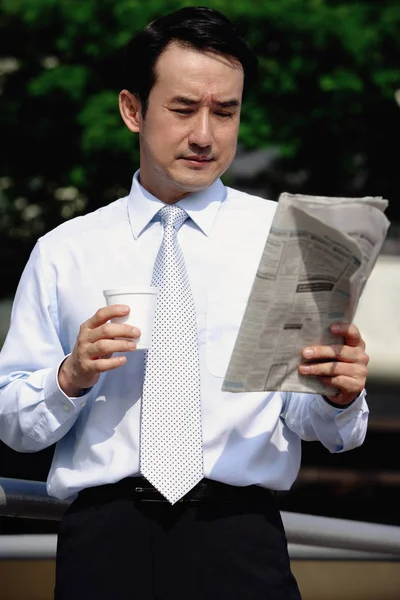 Empresario mirando el periódico — Foto de Stock