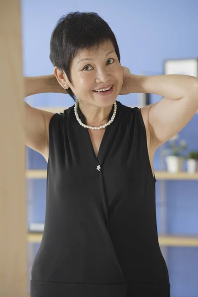 Mujer poniéndose collar de perlas — Foto de Stock