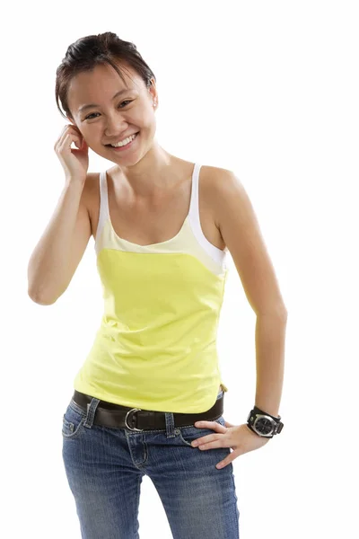 Young woman standing with one hand on hip, smiling — Stock Photo, Image