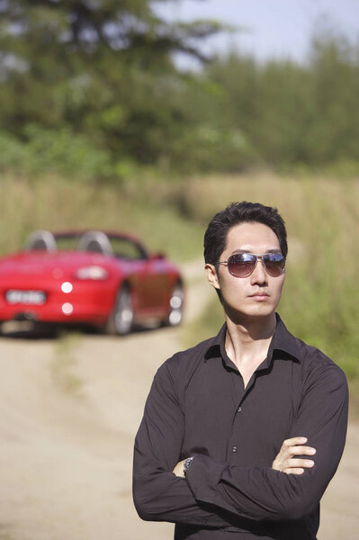 Man wearing sunglasses, arms crossed