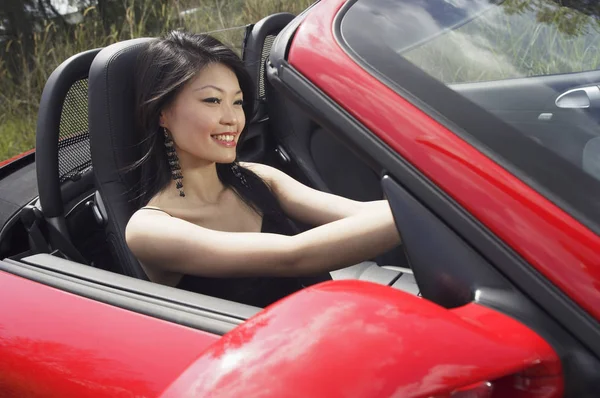 Mujer conduciendo coche deportivo rojo — Foto de Stock