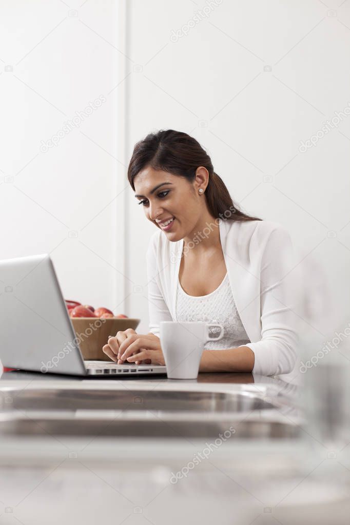  woman using laptop in kitchen