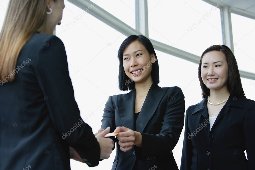 businesswomen exchanging business cards