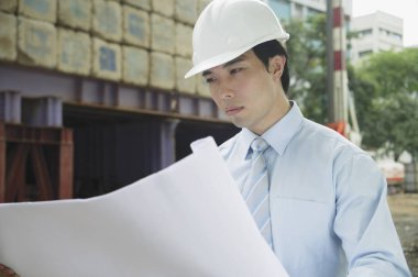 İşadamı planlara bakıyor.