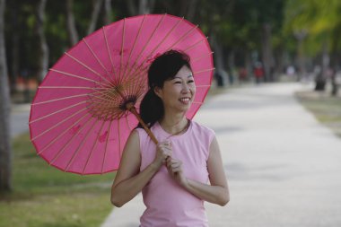 Kadın pembe şemsiye kullanarak