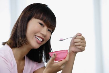 Kadın pembe kaseden yemek