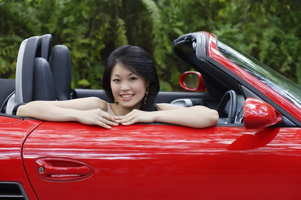 Mujer sentada en coche deportivo rojo — Foto de Stock