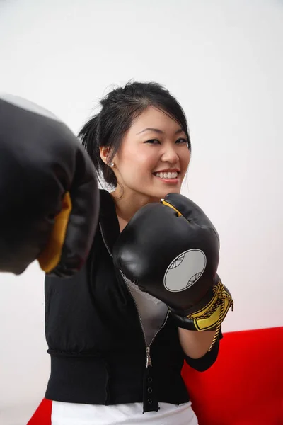 Ung kvinna som bär boxningshandskar — Stockfoto