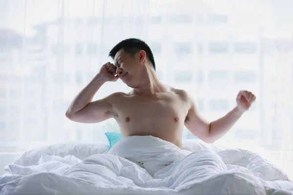 Мужчина сидит в постели — стоковое фото