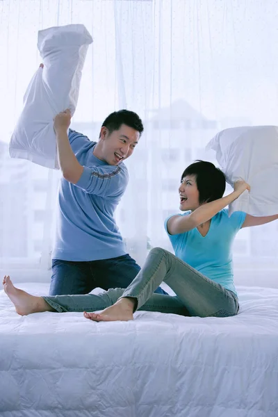 寝室の枕の戦いを持っているカップル — ストック写真