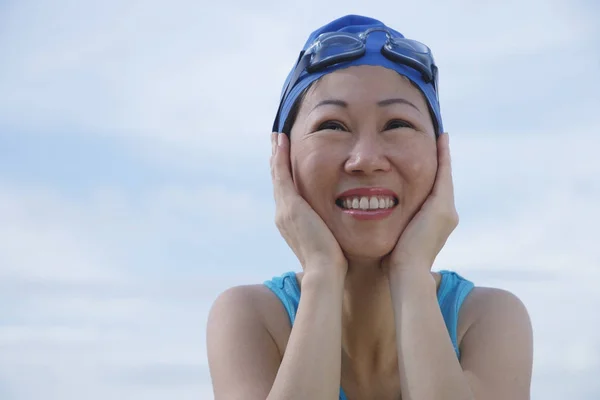 Woman wearing swim cap and goggles