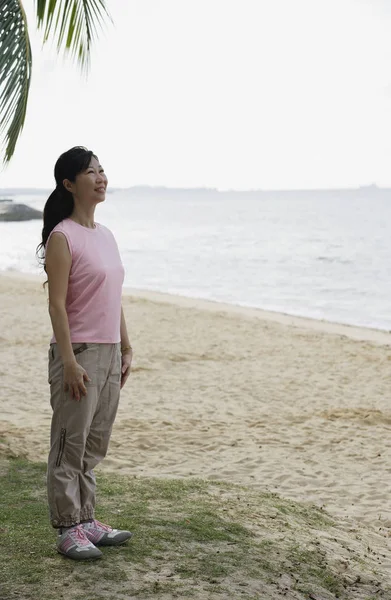 Mujer de pie en la playa — Foto de Stock