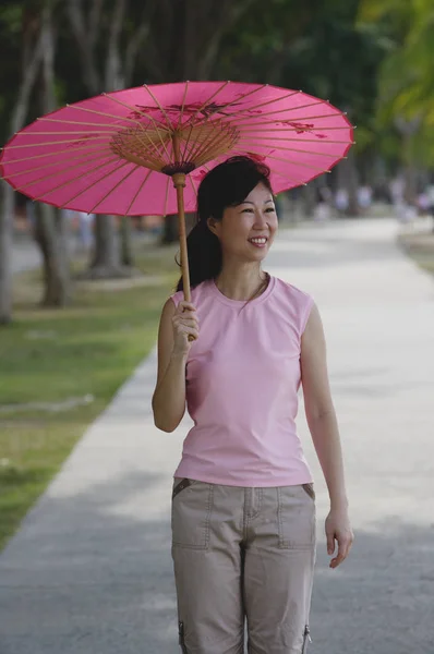 使用粉红色的雨伞的女人 — 图库照片