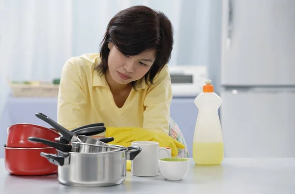 Vrouw in de keuken, leunend op de aanrecht — Stockfoto