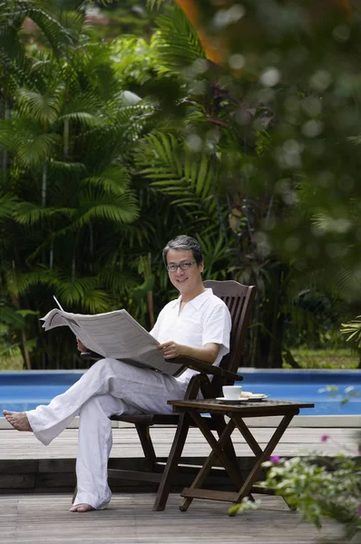 Hombre sentado cerca de la piscina — Foto de Stock