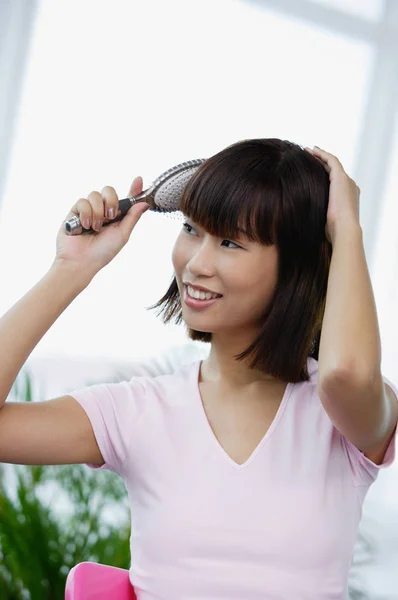 Mujer cepillándose el pelo — Foto de Stock