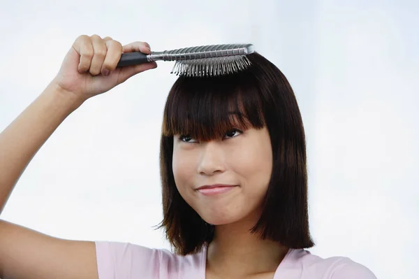 Mulher escovando o cabelo — Fotografia de Stock